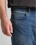 Close-up van de voorkant van een lichtblauwe jeans met een zak aan de zijkant.