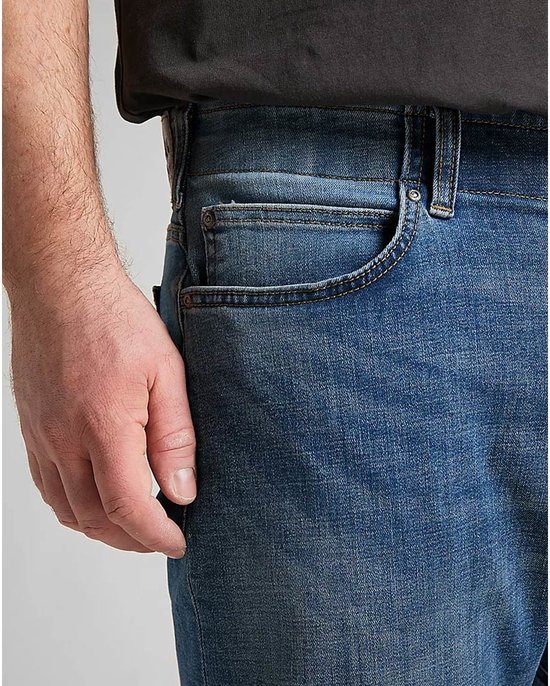 Close-up van de voorkant van een lichtblauwe jeans met een zak aan de zijkant.