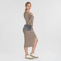 Une femme porte un sac bandoulière Liu Jo anthracite avec une robe.