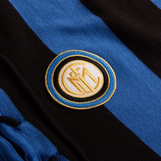 Detailopname van het Inter Milan logo op een blauw-zwart gestreept voetbalshirt.