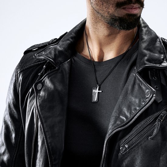 Zwarte stalen dogtagketting met kruisdetail en gravure, gedragen door een man in leren jack.