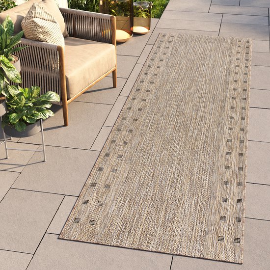 Tapis beige avec motif de rayures noires sur les bords sur une terrasse.