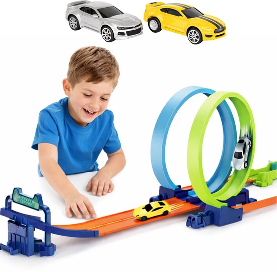 Jongen speelt met gele en zilveren speelgoedauto's op racebaan met blauwe en groene loopings.