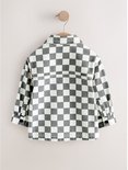 Achterkant van het grijs-witte overshirt met rits, voorzien van een juk en knopen op de mouwboorden.