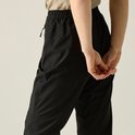 Detail van een zwarte hikingbroek voor dames met elastische tailleband en rits.