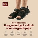 Zwarte BORT verbandsschoenen met klittenbandsluiting, getoond op de voeten van een persoon.