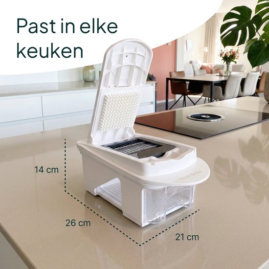 Witte groentesnijder met openklapbare deksel, diverse zwarte snij-inzetstukken en een glazen opvangbak met gesneden groenten, met afmetingen aangegeven.