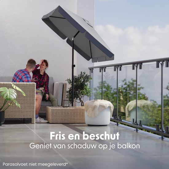 Paar op balkon onder een donkergrijze parasol, genietend van de frisse schaduw.