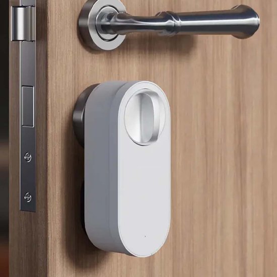 Wit deurslot gemonteerd op een houten deur naast een zilverkleurige deurklink.