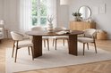 Ovale eettafel van donker hout met vier beige stoffen stoelen met houten frame.