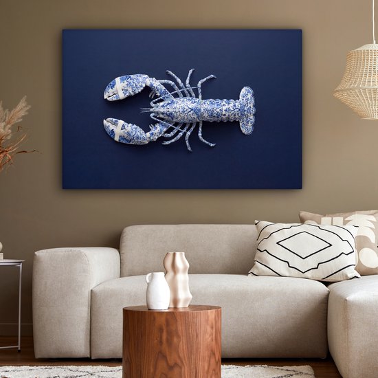 Blauw-wit Delftsblauwe kreeft op een donkerblauwe achtergrond, hangend boven een bank met kussens en salontafel.