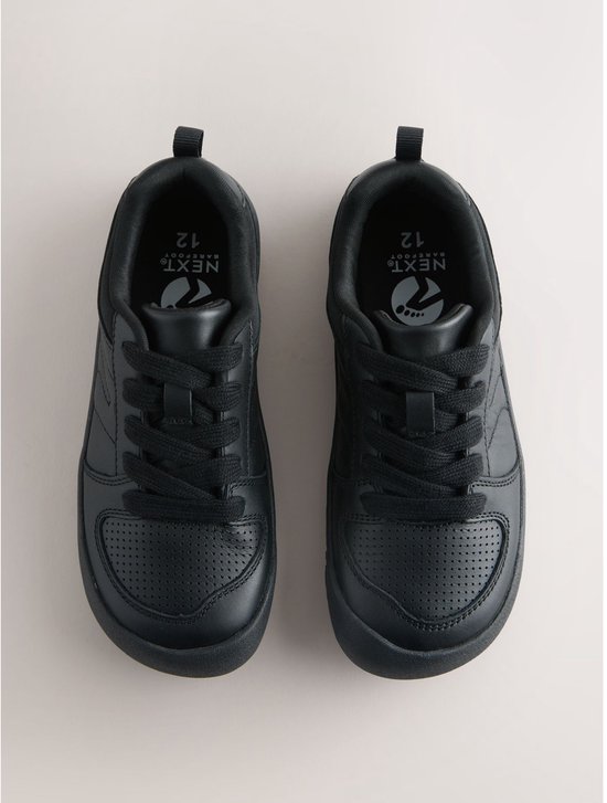 Zwarte leren veter-sneakers, met perforaties op de neus en Next-logo's op de zolen.