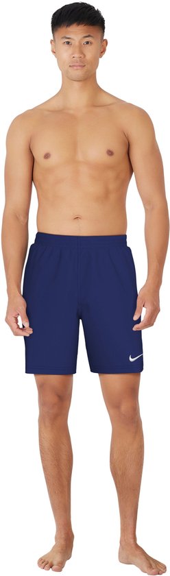 Man met marineblauwe Nike zwembroek met witte swoosh op de linkerpijp.