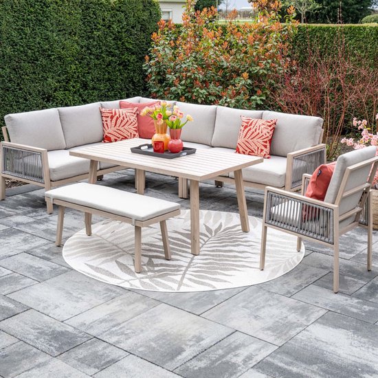 Buiten loungeset met lichte houten bank, stoel, tafel en grijze kussens op betegeld terras.