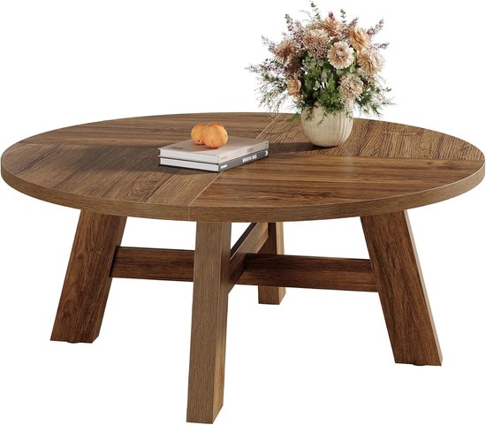 Ronde salontafel met warme walnootkleur, vier poten met horizontale steunen en een vaas met bloemen.