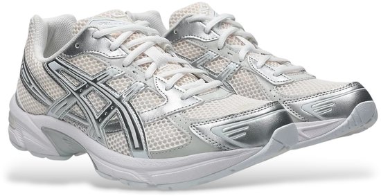 Een paar witte Asics Gel-1130 sneakers met zilverkleurige accenten en witte veters.