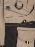 Salopette de jardin beige avec accents noirs, un anneau en D, un bouton avec logo STØRVIK et une poche plaquée.