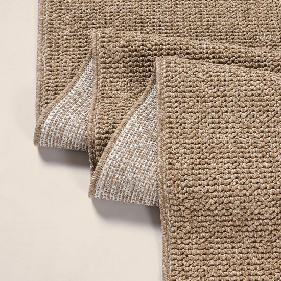 Deux tapis bruns à l'aspect jute, montrant le dessous blanc quadrillé.