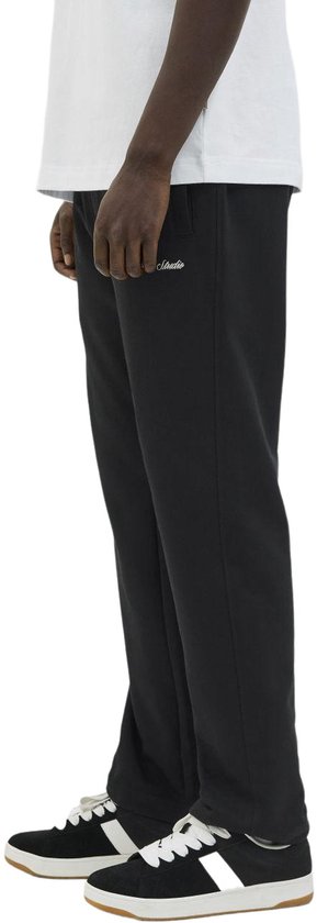 Zij-aanzicht van een zwarte joggingbroek met geborduurde tekst aan de zijkant.