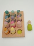 Houten sorteerplank met 12 pastelkleurige peg poppetjes erin, een los poppetje erboven.