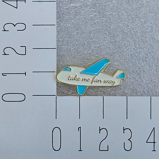 Broche avion blanc avec ailes bleues et texte 'take me fan way'.