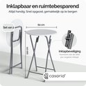 Table haute blanche pliable de 60cm de diamètre et 110cm de hauteur, avec une table pliée à côté. Détail de sécurité de pliage.