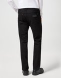 Model draagt zwarte jeans, achterkant zichtbaar, met Wrangler logo.
