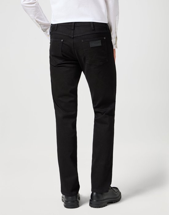 Model draagt zwarte jeans, achterkant zichtbaar, met Wrangler logo.