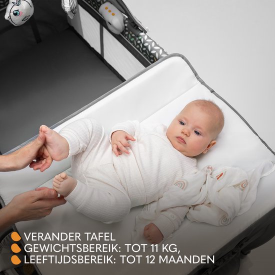 Baby op een grijze commode van een campingbedje. Gewicht- en leeftijdsindicatie.