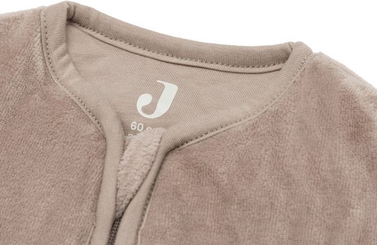Detail van de nek en kraag van een beige, zachte slaapzak met het Jollein logo.