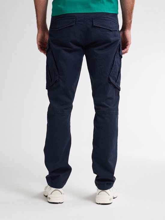 Achterkant van een man die een donkerblauwe cargobroek draagt met opgestikte zakken.