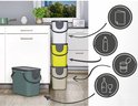 Stapelbare, limegroene en grijze afvalbakken met symbolen voor papier, plastic en glas in een keuken.