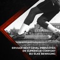 Voeten van een atleet in witte sportsokken op gras, klaar om te rennen.
