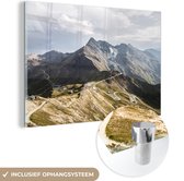 MuchoWow® Glasschilderij 120x80 cm - Schilderij acrylglas - Wolkenlucht boven een berglandschap - Foto op glas - Schilderijen