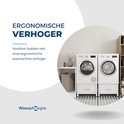 Twee witte wasmachines op witte ladekasten, in een nette wasruimte met een kast en manden.