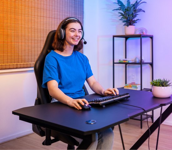 Jonge vrouw met headset speelt op een zwart gaming toetsenbord.