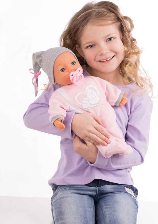 Meisje met babypop in roze slaappakje en grijze muts.