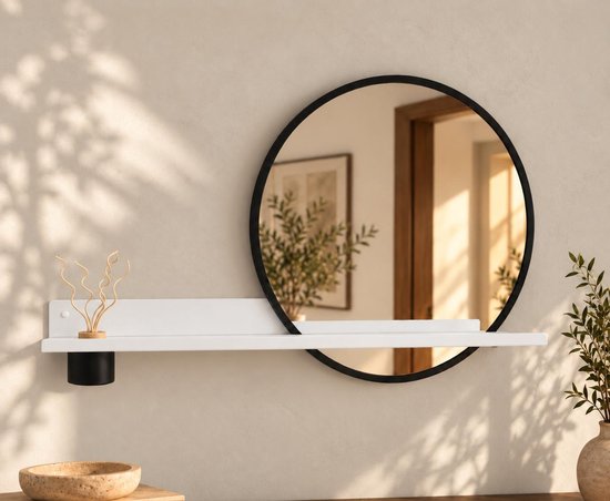 Witte wandplank met ronde zwarte spiegel en decoratieve houten diffuser.