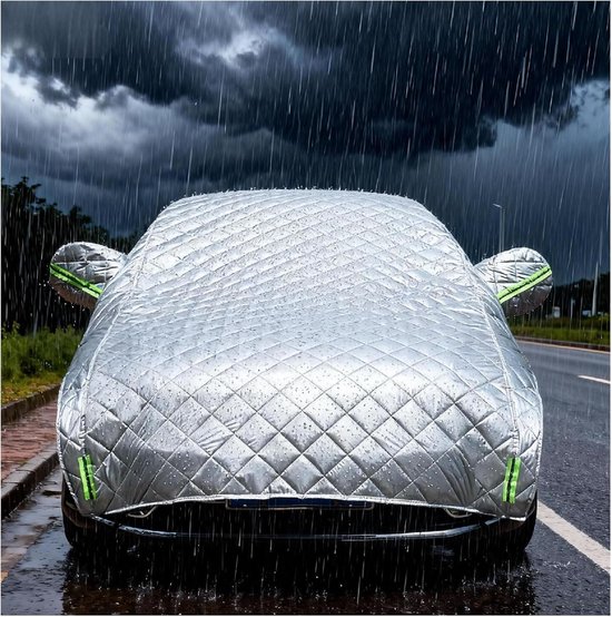 Zilveren autohoes met ruitpatroon op een natte weg, beschermt tegen zware regen.