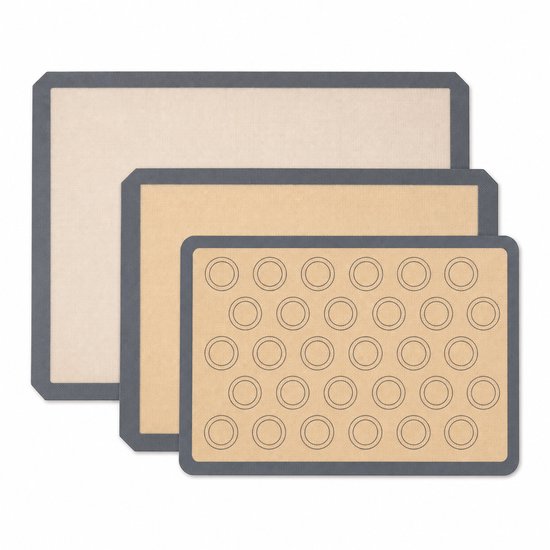 Drie opgestapelde siliconen bakmatten: een grote, een middelgrote blanco mat en een macaronmat met 30 cirkels.