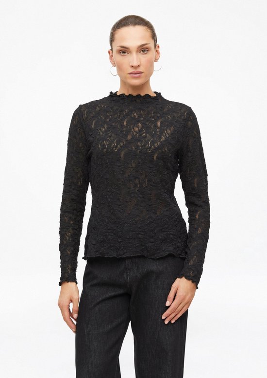 Vooraanzicht van een zwart kanten shirt met lange mouwen, opstaande kraag en golvende randen, gedragen op een zwarte jeans.