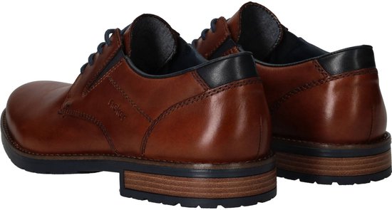 Bruine leren Rieker veterschoenen, gezien vanaf de achterkant. De schoenen hebben donkerblauwe accenten bij de hiel.