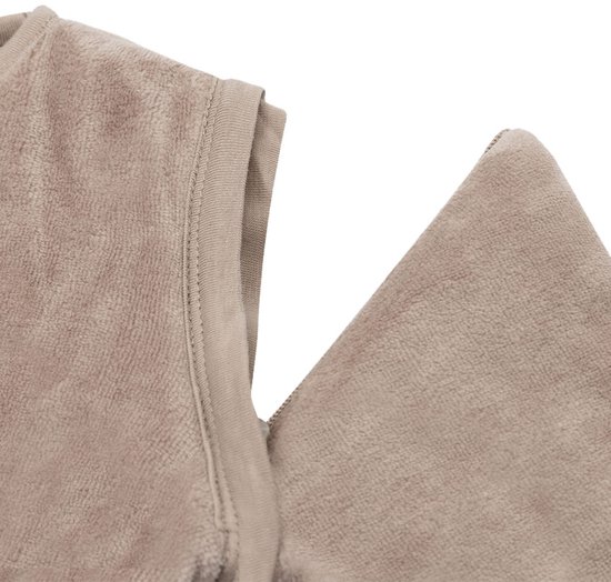 Gedetailleerde foto van de schouder en rits van een mouwloze beige slaapzak.