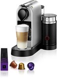 Zilveren Krups Nespresso Citiz & Milk koffiemachine met zwarte melkopschuimer, glazen latte en Nespresso capsules.