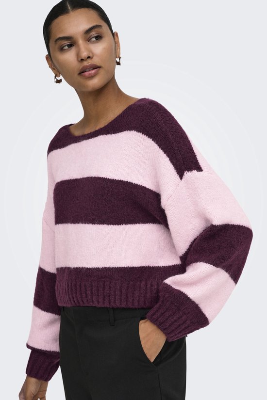 Een model draagt een trui met horizontale strepen in roze en bordeauxrood. De trui heeft een boot hals en lange mouwen.