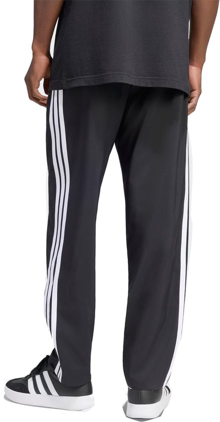 Zwarte sportbroek voor heren met witte Adidas strepen op de zijkanten.