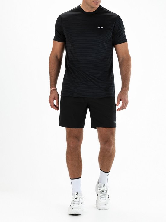 Man draagt een zwart sportshirt met horizontaal streeppatroon en het witte SJS-logo, gecombineerd met zwarte shorts.