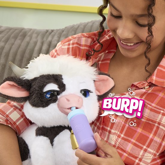 Kind knuffelt FurReal Riley koe die uit een flesje drinkt met de tekst BURP!