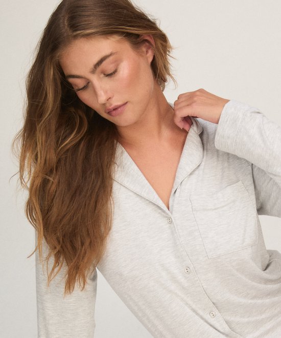 Close-up van het bovenlichaam in een grijze jersey shirtdress met borstzak.
