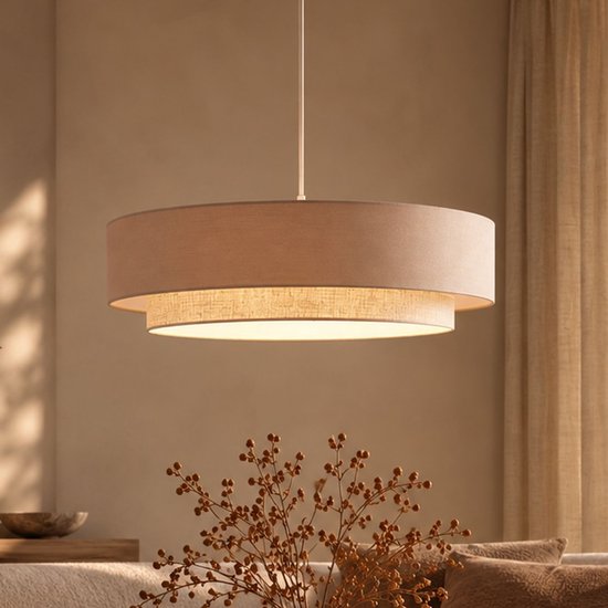 Beige dubbele hanglamp in een sfeervol interieur met warme verlichting, boven een woonkameropstelling.